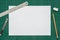 Old green dirty cutting mat, with empty white paper A4 size, stainless steel ruler, cutter knife, pencil and eraser, top view of