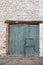 Old green double-hung barn door with wooden lintel