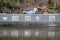 Old green houseboat moored on a canal reflecting in the water