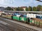 Old green locomotive with goods wagons at rail station