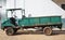 The old green pickup truck is parked on the cement floor.