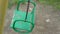 Old green swing with rusty chains and peeling paint closeup