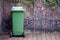 Old green trash bin on wooden floor in the community