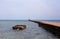 Old green and white light house in the end of the pier. No people on the photo, calm relaxing atmosphere, free copy