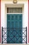 Old green wooden balcony doors with wooden shutters and metal bars in the Greek style balcony