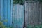 Old green wooden door on a rural blue gray fence