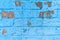 Old grunge brick wall of a background or texture painted in blue paint that cracked under the influence of time and weather