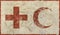 Old grunge faded flag of Red Cross and Crescent