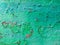Old grunge vintage background: rusty metal surface with green red paint flaking and cracking texture