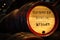 Old grungy wooden Guinness barrels resting in rows in brewery cellar, blurred background