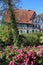 Old half-timbered townhall with garden flowers and tree