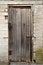 Old Halloween spooky wooden door with a lock in white brick wall