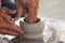 An old hand help and teaching a kid to making a vase pottery together