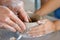 An old hand teaching and helps a child to making a vase pottery