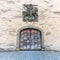 Old handmade medieval wooden gate with a commemorative town seal above in an idyllic small European village