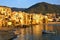 Old harbor at sunset with fishing boat, Cefalu, Sicily, Italy