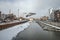 Old harbour canal with marina in ice and snow during winter in Old Town of Gdansk Poland. Old town in the background.