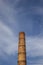 an old heating station in the countryside with a damaged brick pipe