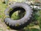 Old heavy duty automobile tyre covered in moss abandoned near a rustic stone wall