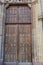 Old heavy square, wooden, massive, shafted door in stone wall to enter St. Martin`s Church in Gothic architectural style