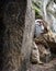 Old hermit peeks behind rock.