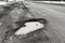 old highway with holes and snow. Landscape road potholes in cloudy winter weather. concept absence of timely repair of highway.