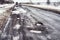 old highway with holes and snow. Landscape road potholes in cloudy winter weather. concept absence of timely repair of highway.