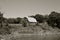 Old hip roofed barn on river bank