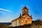 Old and historic 18th century church with its facade illuminated at dusk