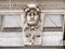 Old historic building antique sculpted head, face architectural detail behind a safety net, architecture, historical buildings