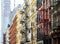 Old historic buildings in SoHo contrast against a modern tower in New York City