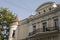 Old historic stone house on the yard with trees around. Old city buildings before and after restavration. Ancient windows, roofs,