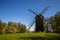 Old historic windmill in between green trees, in Estonia, blue sky