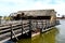 Old, historic wooden floating boat mill on green river water.