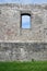 Old, historical and antique wall made of stone.  Facade with window.