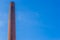 Old historical stone chimney burner, old factory architecture, blue sky in the background