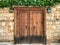 An old historical stone wall with a wooden door gate in Antalya Old town Kaleici, Turkey. Ottoman time architecture. Horizontal