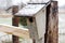 Old Homemade Birdhouse on Farm Fence in Snow