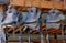 Old horse saddles hanging in a barn in a row