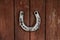 An old horseshoe hangs on old wooden doors.The concept of tradition of different peoples