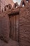 Old house with an artisanal wooden door in Taghit, Ksar