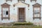 Old house with broken and boarded up shutters