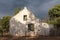 Old house in De Rust against backdrop of dark clouds