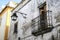 Old house with old forged iron balcony and vintage streetlight