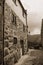 Old house with stone wall in a deserted alley