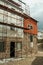 Old house with stone wall and scaffolding for refurbishment