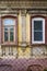 An old house with a stucco ornament, a fragment of the facade with windows