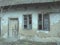 Old house with windows and a door. Collapsing rural house. The concept of urbanization and oblivion of the motherland. Abandoned