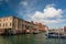 Old houses, boats, lagoon waters around island of Giudecca under blue sky