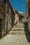 Old houses in deserted alley with steps on slope